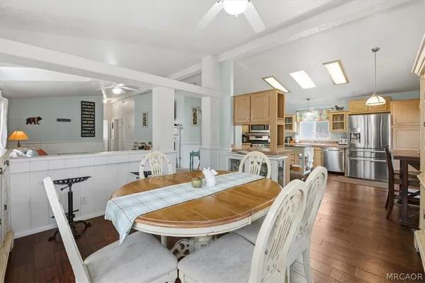a kitchen that has a lot of white cabinets and stainless steel appliances
