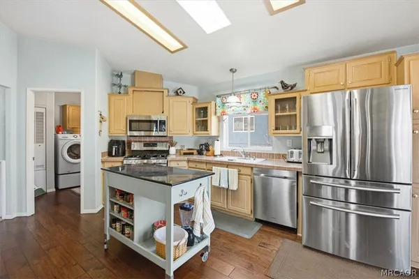 a kitchen with stainless steel appliances granite countertop a stove refrigerator and a sink