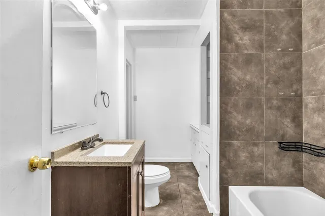 a bathroom with a sink and mirror with toilet