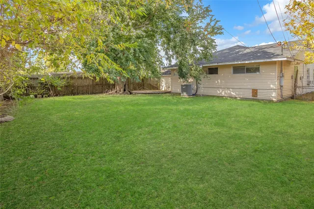 a view of a backyard with a garden and tree