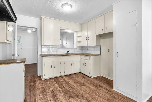 a kitchen with granite countertop white cabinets and white appliances