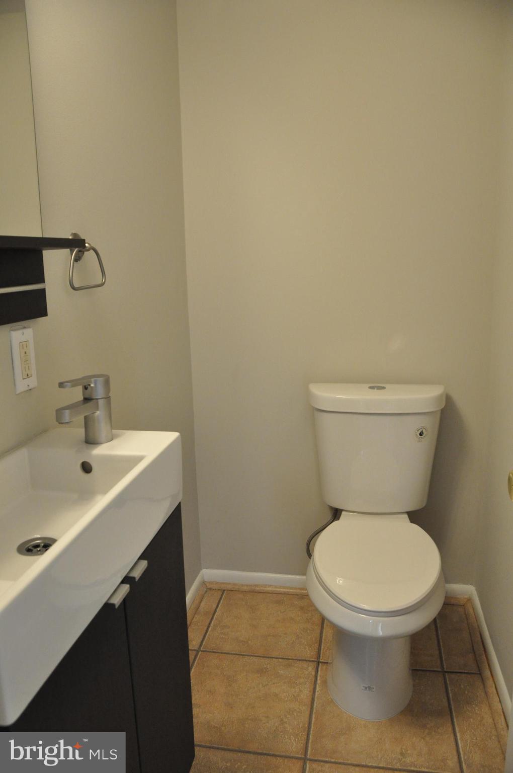 9705 Glen Avenue Silver Spring, MD 20910 - Photo 19 of 47 a bathroom with a toilet a sink and mirror