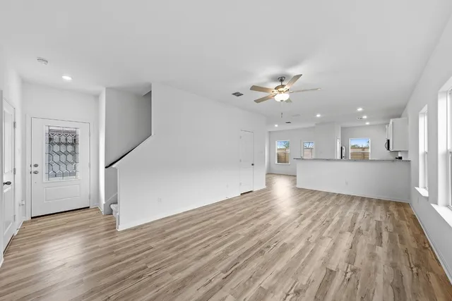 a view of a kitchen with wooden floor and a kitchen space with a sink