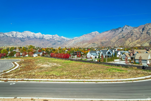 5014 West Jonathon Road American Fork, UT 84003 - Photo 2 of 4 Expansive land parcel featuring a paved road frontage, curved sidewalk, and surrounding residential properties
