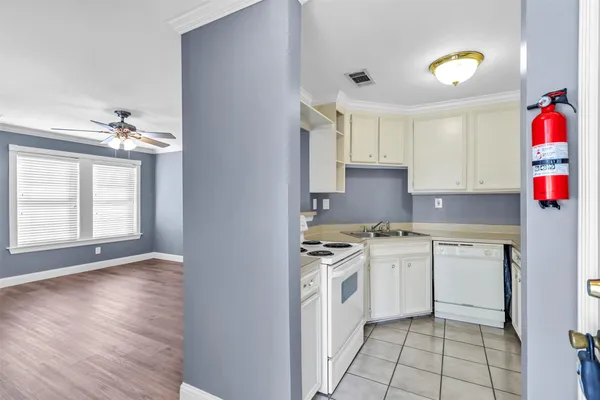 a kitchen with white cabinets and appliances