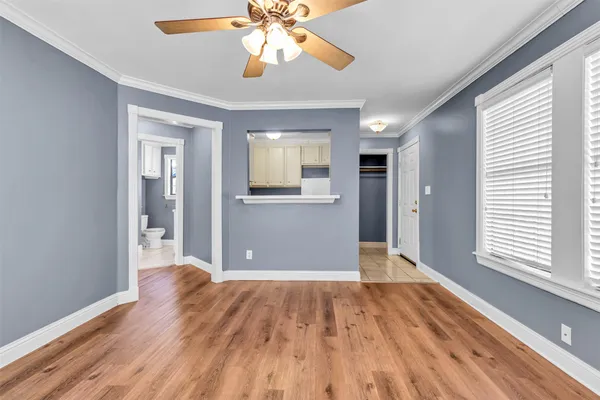 a view of a big room with wooden floor and a chandelier fan