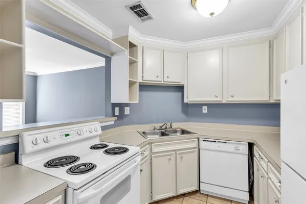 a kitchen with a refrigerator and white cabinets