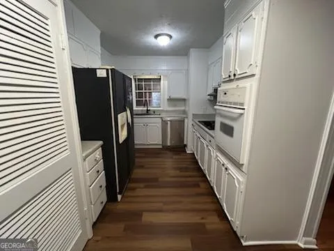 a kitchen with sink a refrigerator and cabinets