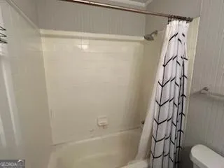 a bathroom with a shower curtain and a toilet