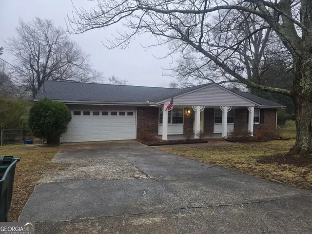 a view of a house with a yard and large tree