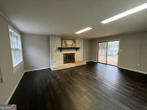 809 College Street Carrollton, GA 30117 - Photo 8 of 33 an empty room with wooden floor fireplace and windows