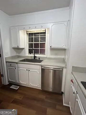 a kitchen with granite countertop white cabinets and white appliances