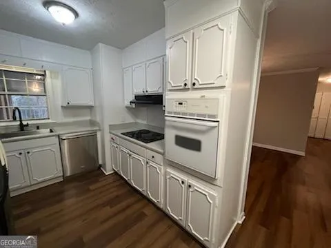 a kitchen with granite countertop white cabinets and white appliances