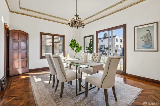 a dining room with furniture a chandelier and wooden floor