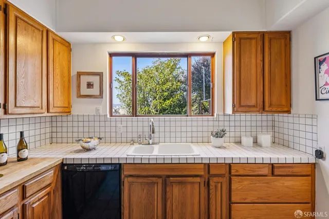 a kitchen with granite countertop cabinets stainless steel appliances and a sink