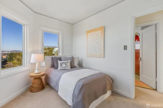 a bedroom with a large bed and a potted plant