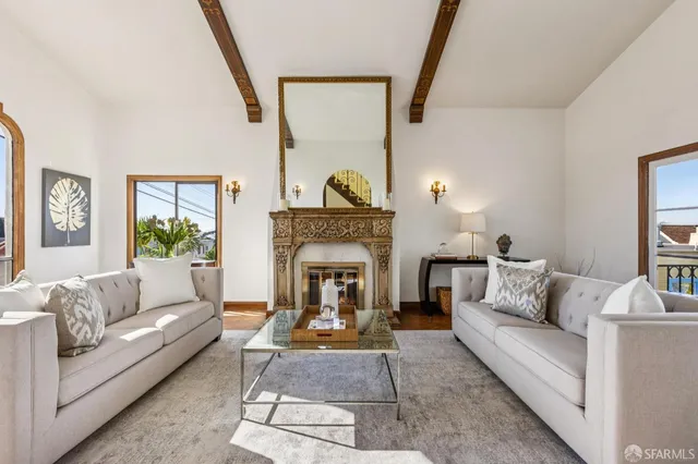 a living room with furniture a fireplace and a potted plant