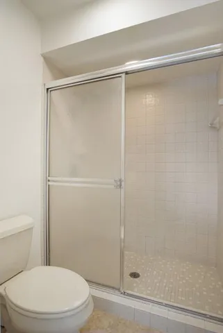 a white toilet sitting next to a shower