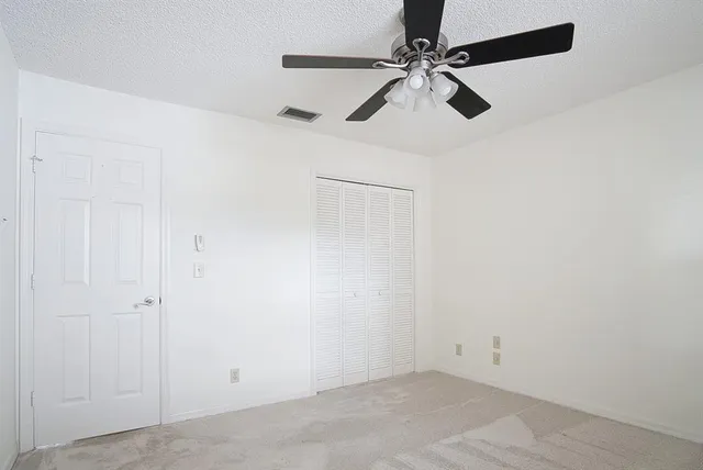 an empty room with a window and a fan