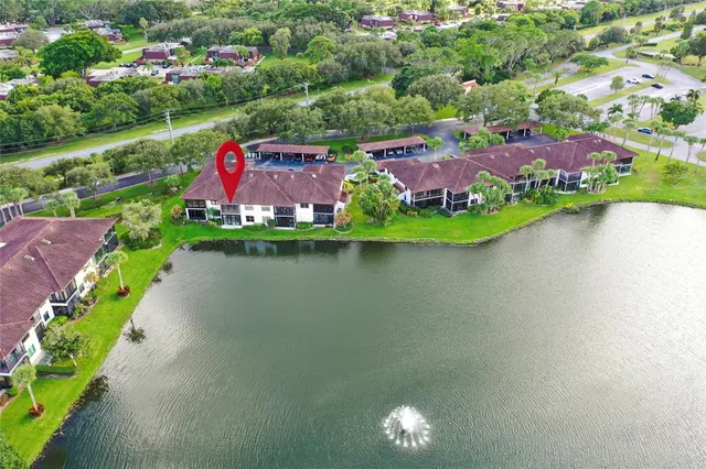 an aerial view of a house with a garden and lake view
