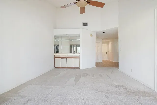an empty room with kitchen view and a fireplace