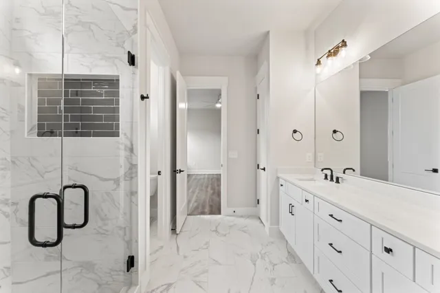 a bathroom with a double sink shower and a mirror