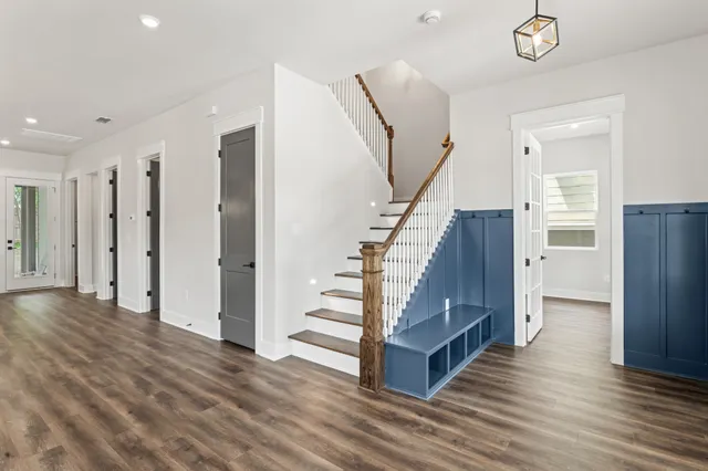a view of a hallway with wooden floor and staircase