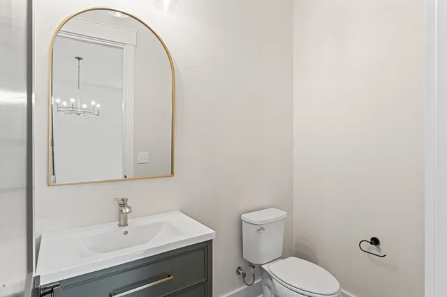 a bathroom with a toilet a sink and mirror