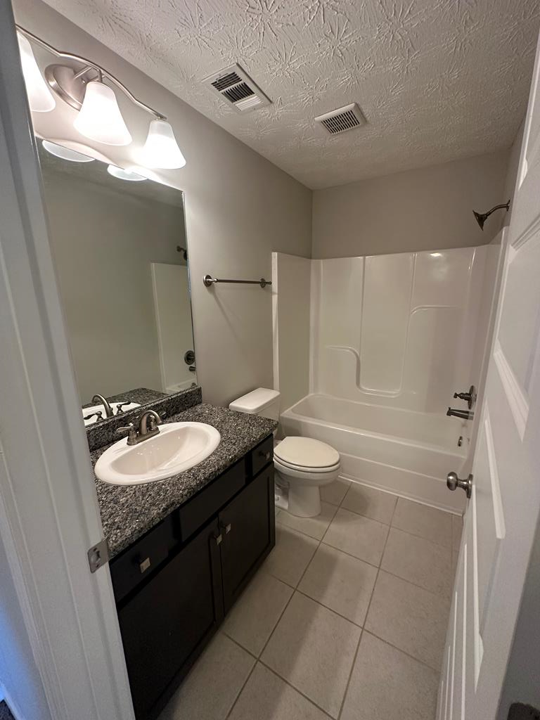 6008 Townes Way Columbus, GA 31909 - Photo 21 of 22 a bathroom with a granite countertop sink toilet and shower