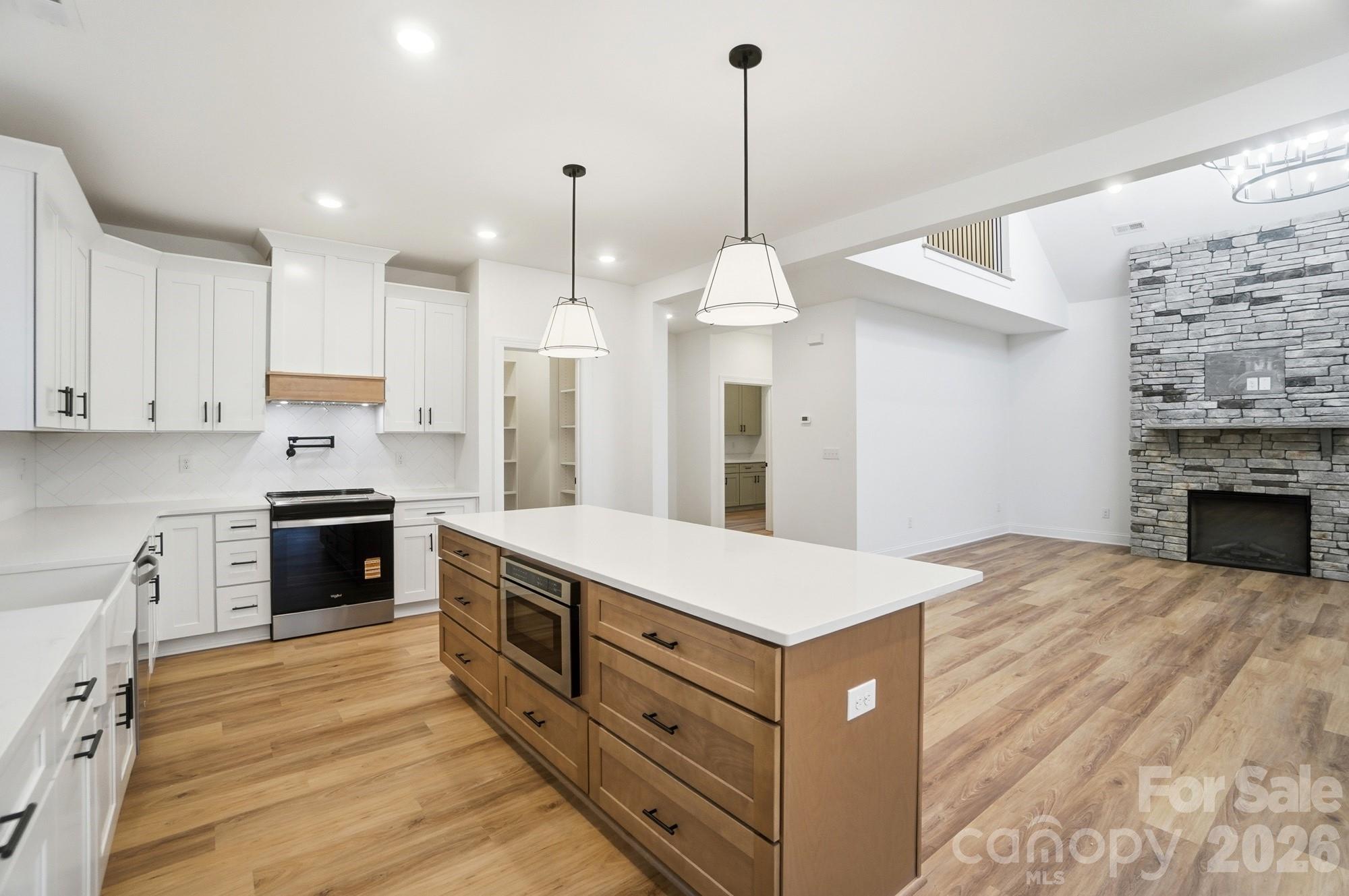 240 Hephzibah Church Road Crouse, NC 28033 - Photo 15 of 48 a kitchen with stainless steel appliances kitchen island granite countertop a sink a stove and a wooden floors