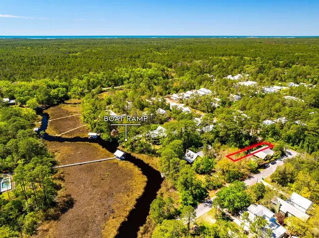 an aerial view of residential houses with outdoor space and trees