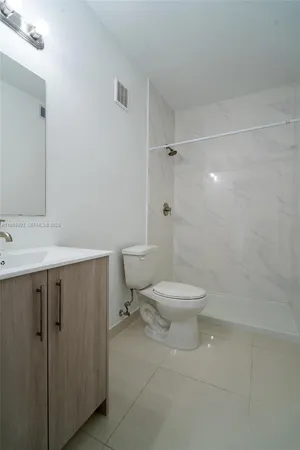 a view of kitchen with refrigerator and cabinets