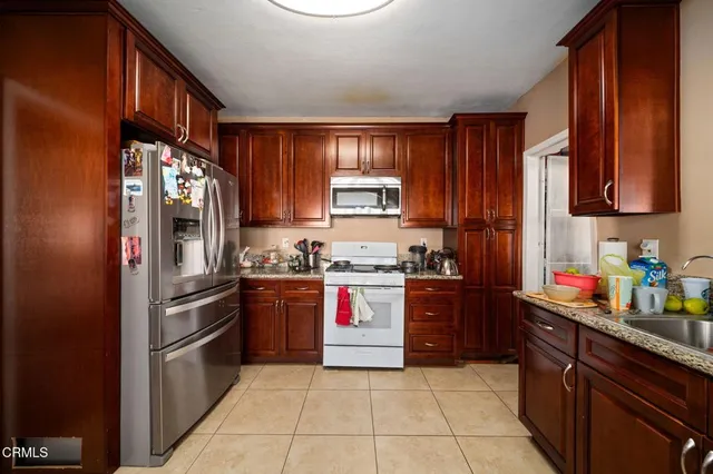 a kitchen with stainless steel appliances granite countertop a refrigerator and a stove top oven
