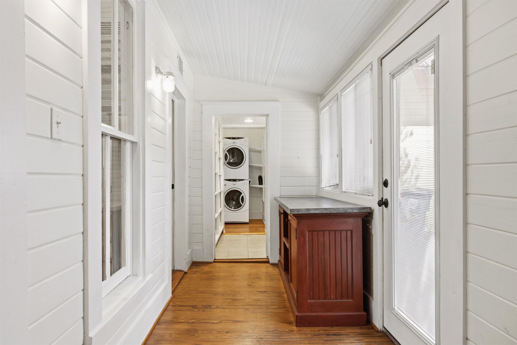 1613 Drake Avenue Austin, TX 78704 - Photo 15 of 27 Hallway with wood-finish flooring, white shiplap walls, and a white beadboard ceiling