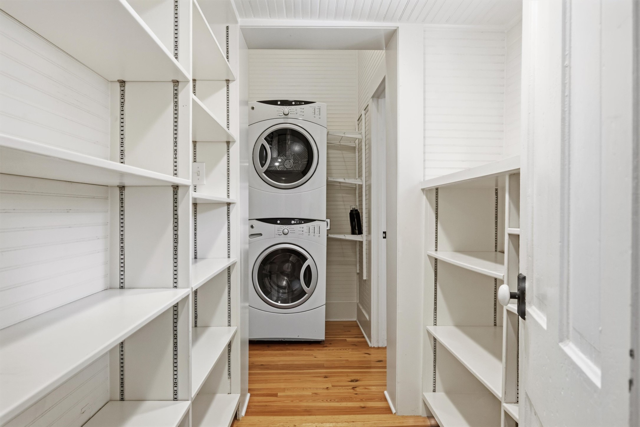1613 Drake Avenue Austin, TX 78704 - Photo 16 of 27 Dedicated laundry area featuring a stacked washer and dryer, accompanied by extensive built-in shelving