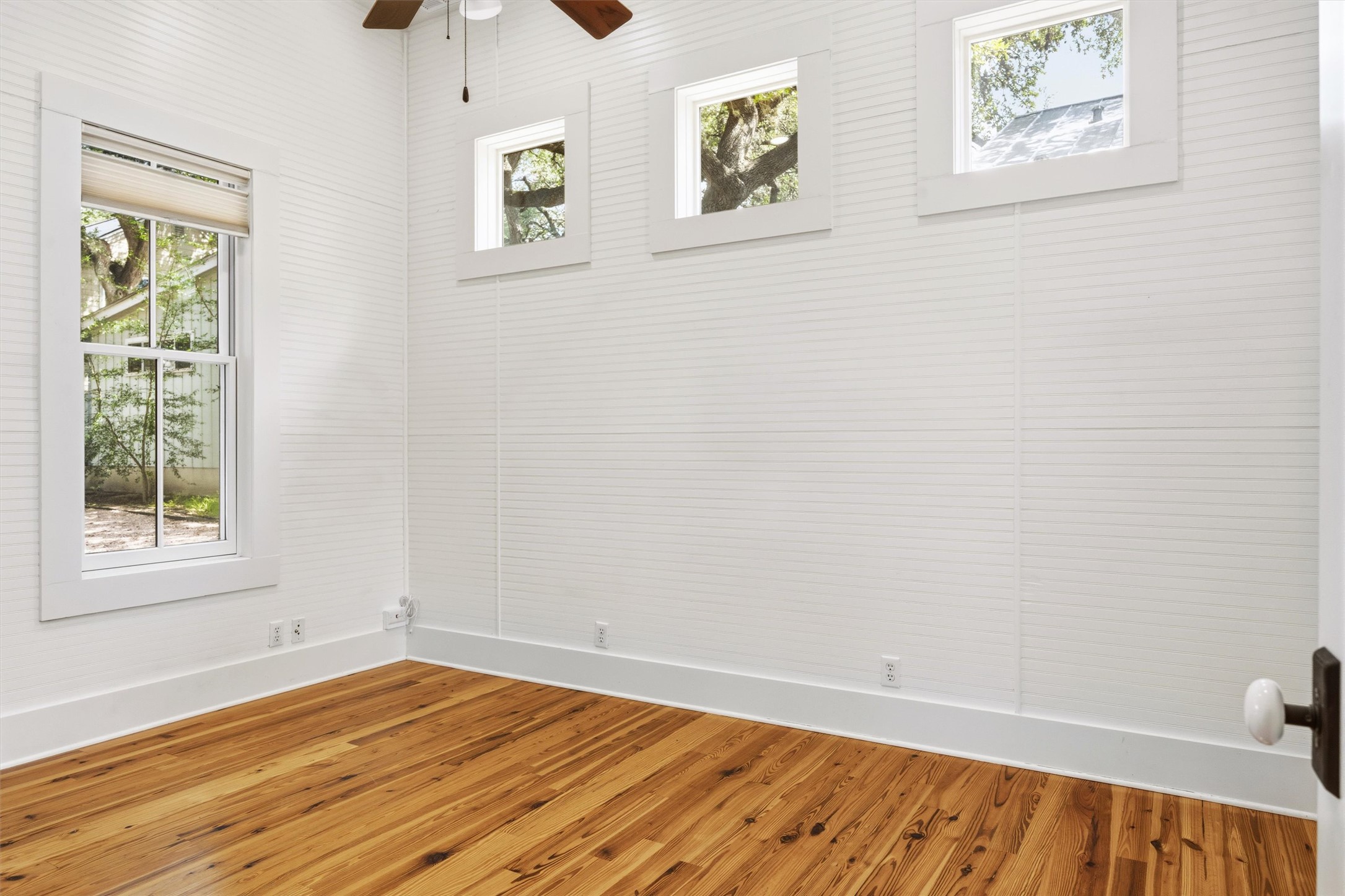 1613 Drake Avenue Austin, TX 78704 - Photo 20 of 27 Room featuring white shiplap walls, wood-finish flooring, and multiple windows