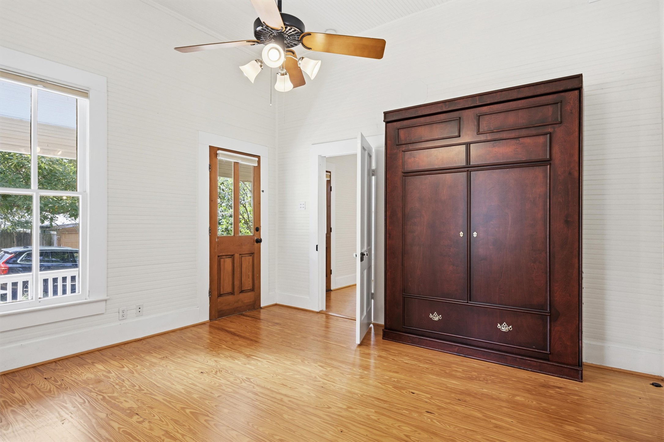 1613 Drake Avenue Austin, TX 78704 - Photo 7 of 27 Bedroom with wood-finish flooring, a ceiling fan with integrated lighting, a built-in bed, and a multi-pane wood door
