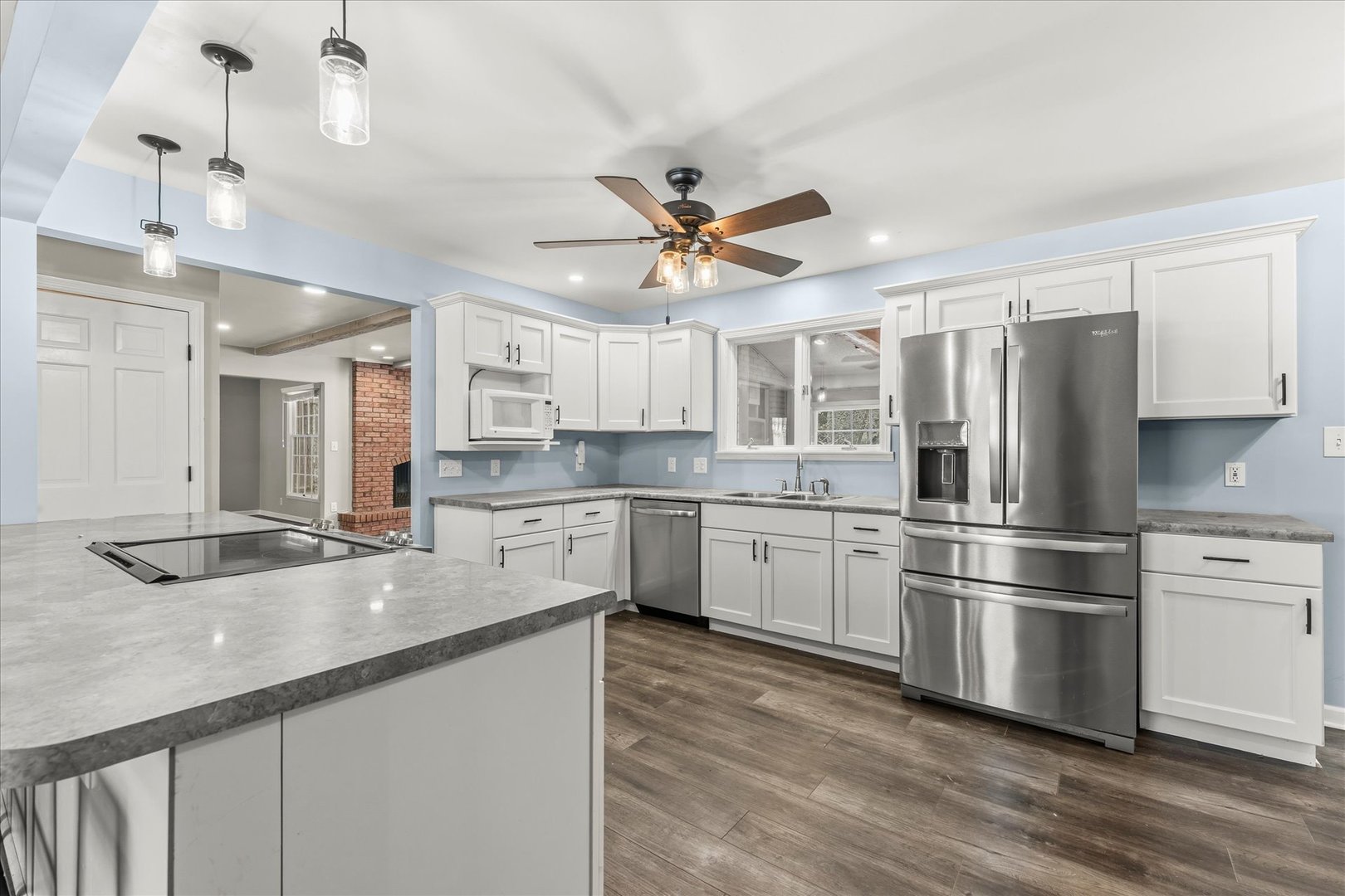 142 Lake Road Seymour, IL 61875 - Photo 12 of 49 a kitchen with stainless steel appliances granite countertop a refrigerator a sink dishwasher a stove and white countertops with wooden floor