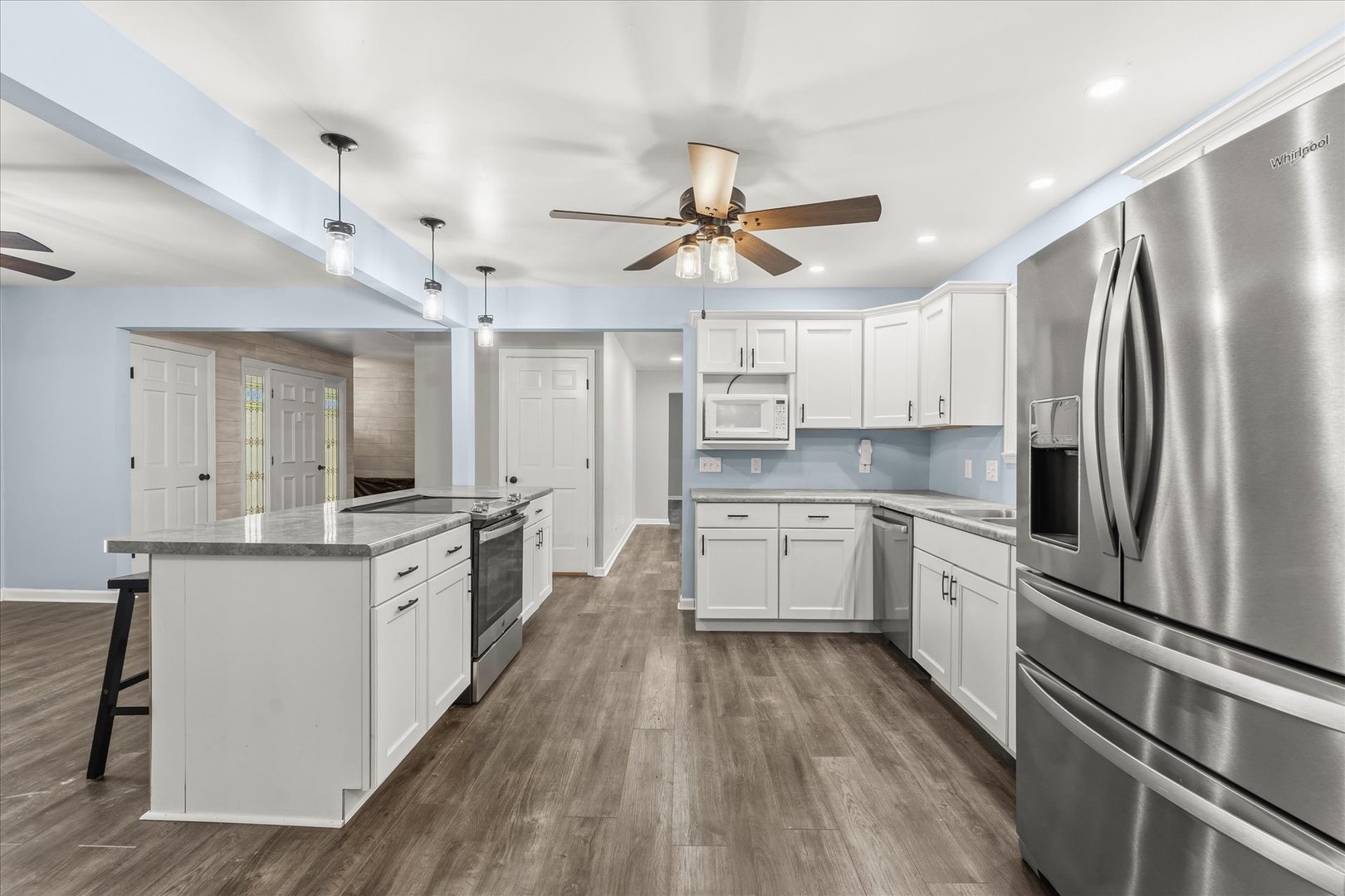142 Lake Road Seymour, IL 61875 - Photo 13 of 49 a kitchen with stainless steel appliances a stove a sink dishwasher a refrigerator and white cabinets with wooden floor