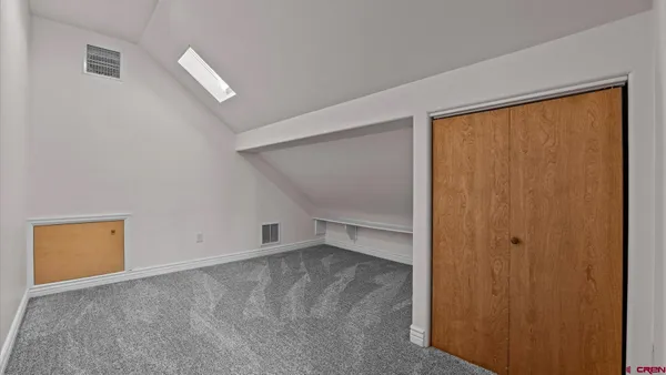 an empty room with windows and closet