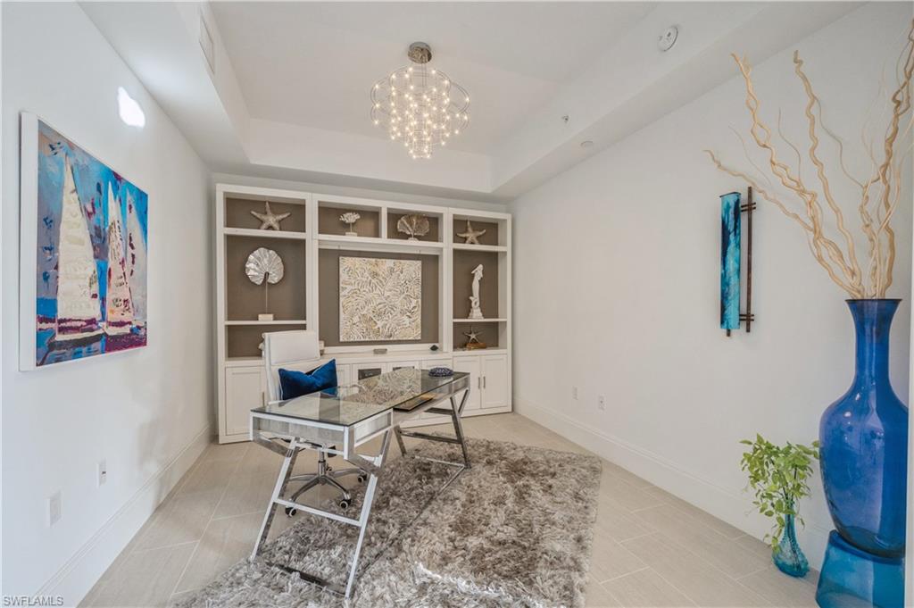 1135 3rd Avenue South, Unit 304 Naples, FL 34102 - Photo 7 of 35 Home office with a chandelier, built in shelves, and a tray ceiling