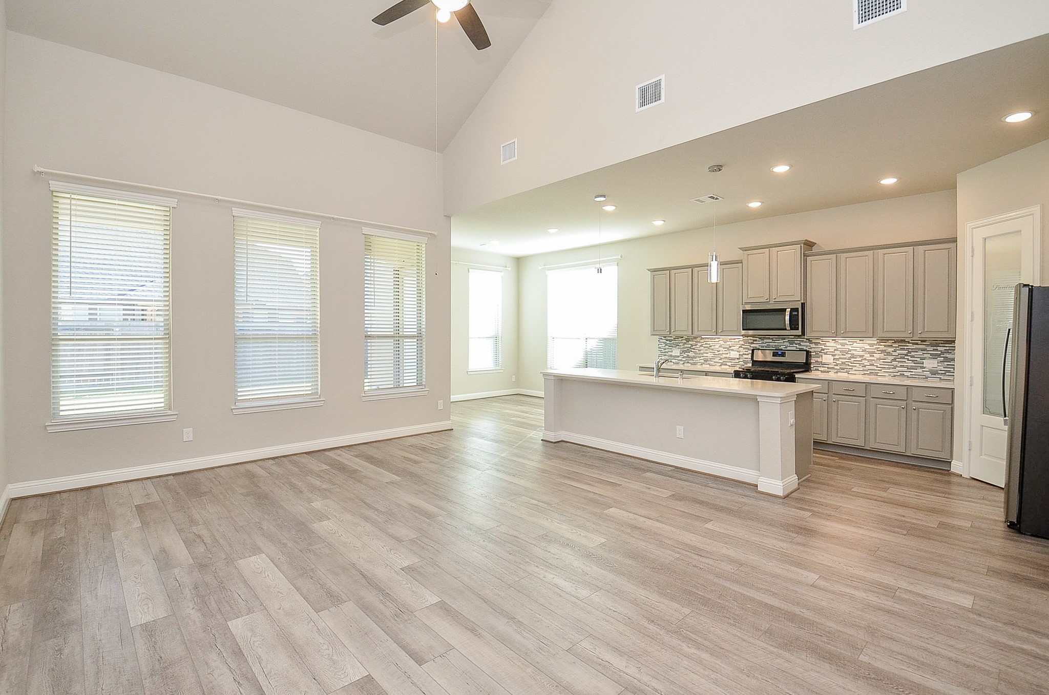 338 Summer Landing Court Rosenberg, TX 77469 - Photo 18 of 50 a large kitchen with kitchen island white cabinets and stainless steel appliances