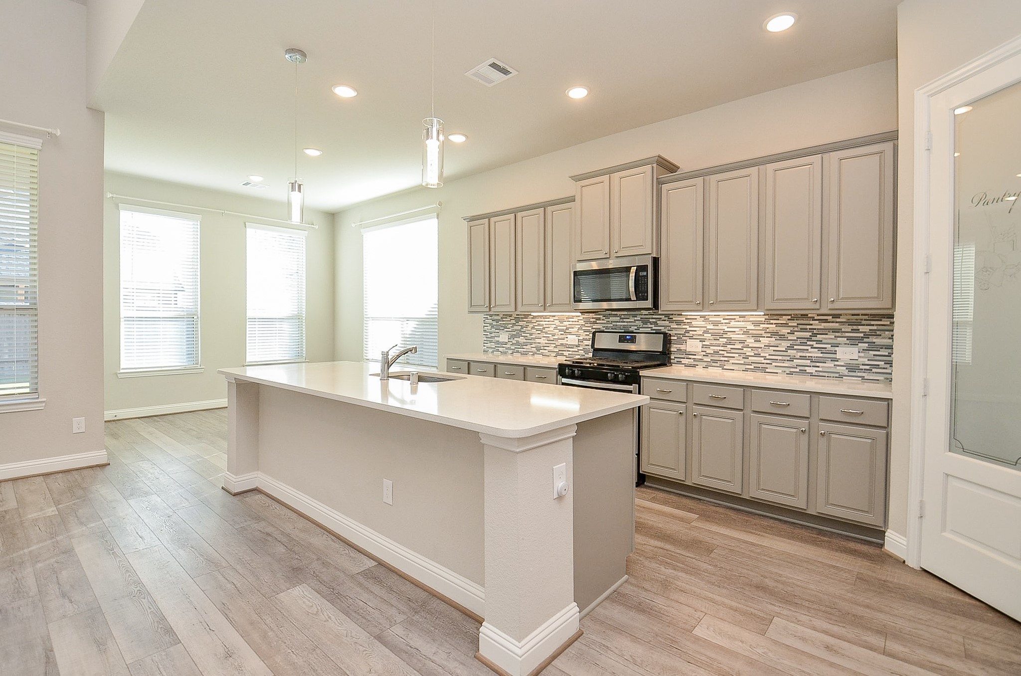 338 Summer Landing Court Rosenberg, TX 77469 - Photo 30 of 50 a kitchen with sink a microwave and cabinets