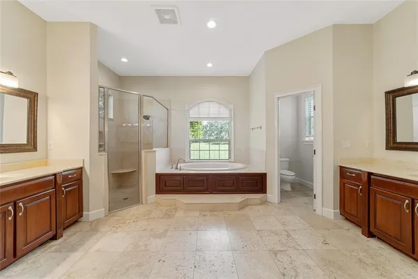 a spacious bathroom with a double vanity sink large mirror and a bathtub