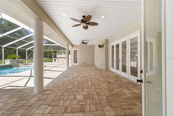 a front view of a house with swimming pool and porch with furniture