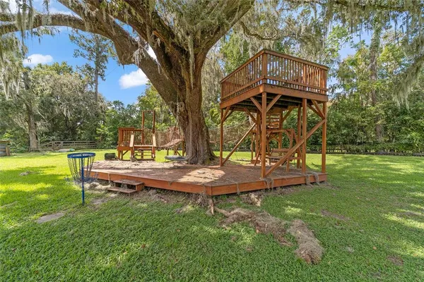 a view of a green field with wooden fence
