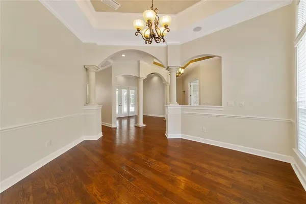a view of a room with wooden floors and chandelier