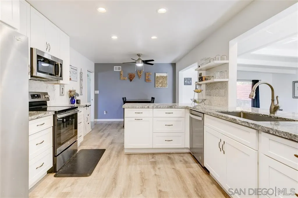 a kitchen with granite countertop a sink stainless steel appliances and cabinets