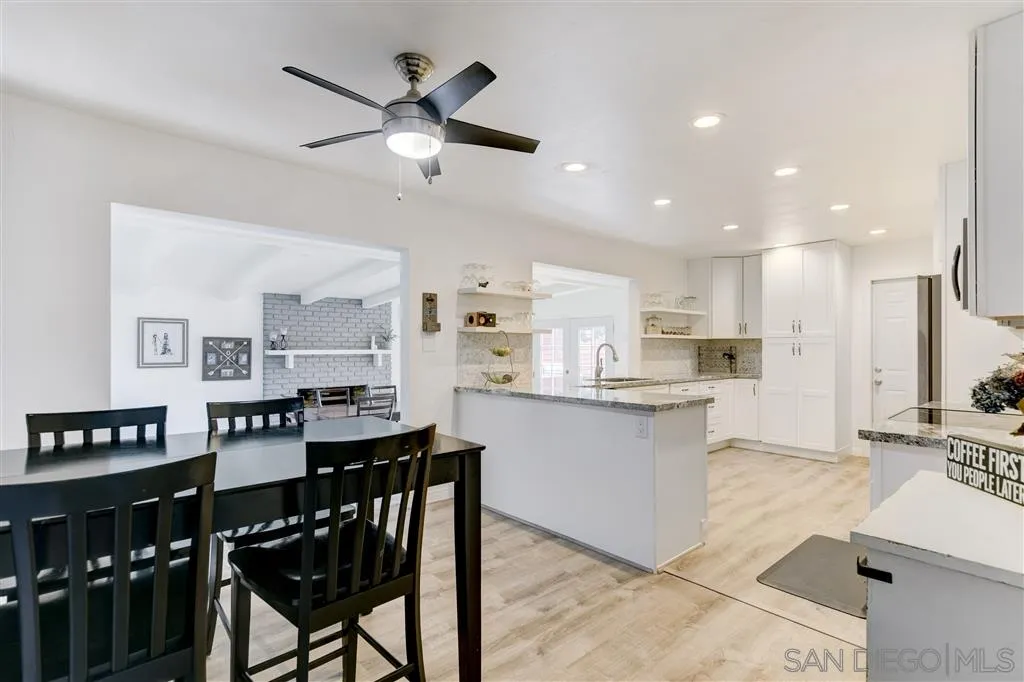 1985 La Cresta Road El Cajon, CA 92021 - Photo 10 of 25 a kitchen with stainless steel appliances kitchen island granite countertop a dining table chairs and a refrigerator