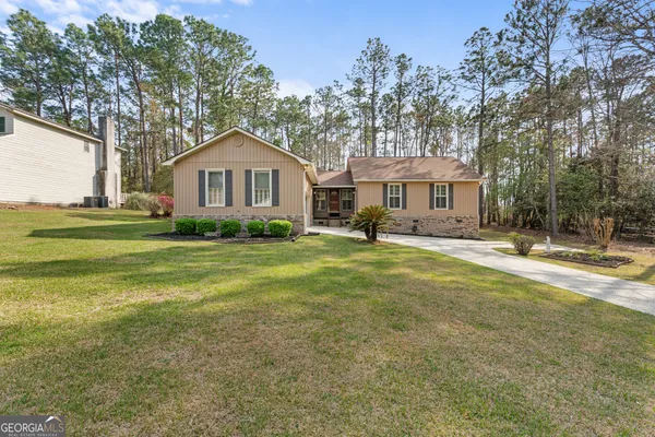 a front view of a house with a yard and trees